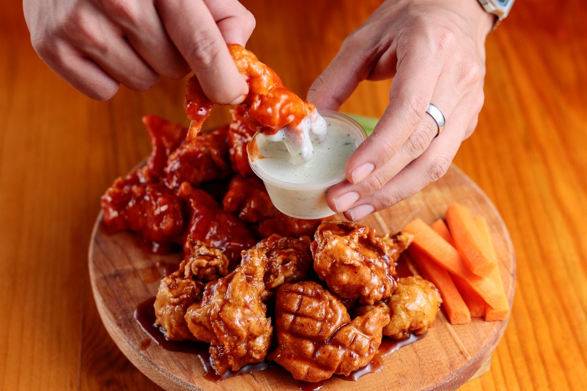 Platter of sauced chicken wings with dip and vegetables