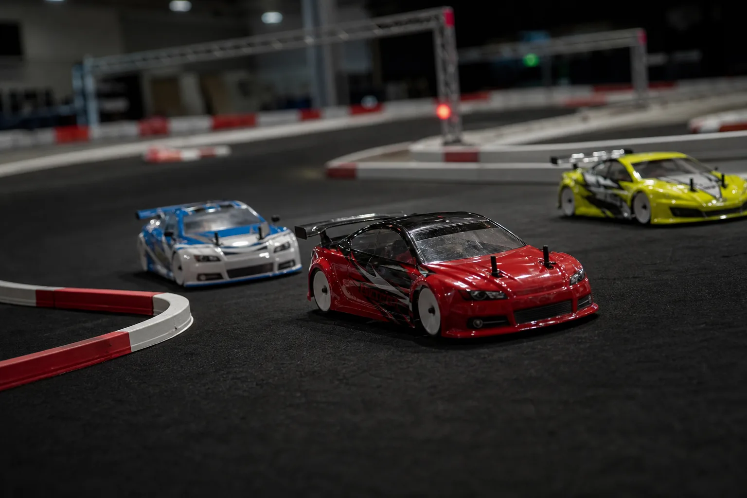Three realistic RC touring cars racing through a corner on an indoor carpet circuit
